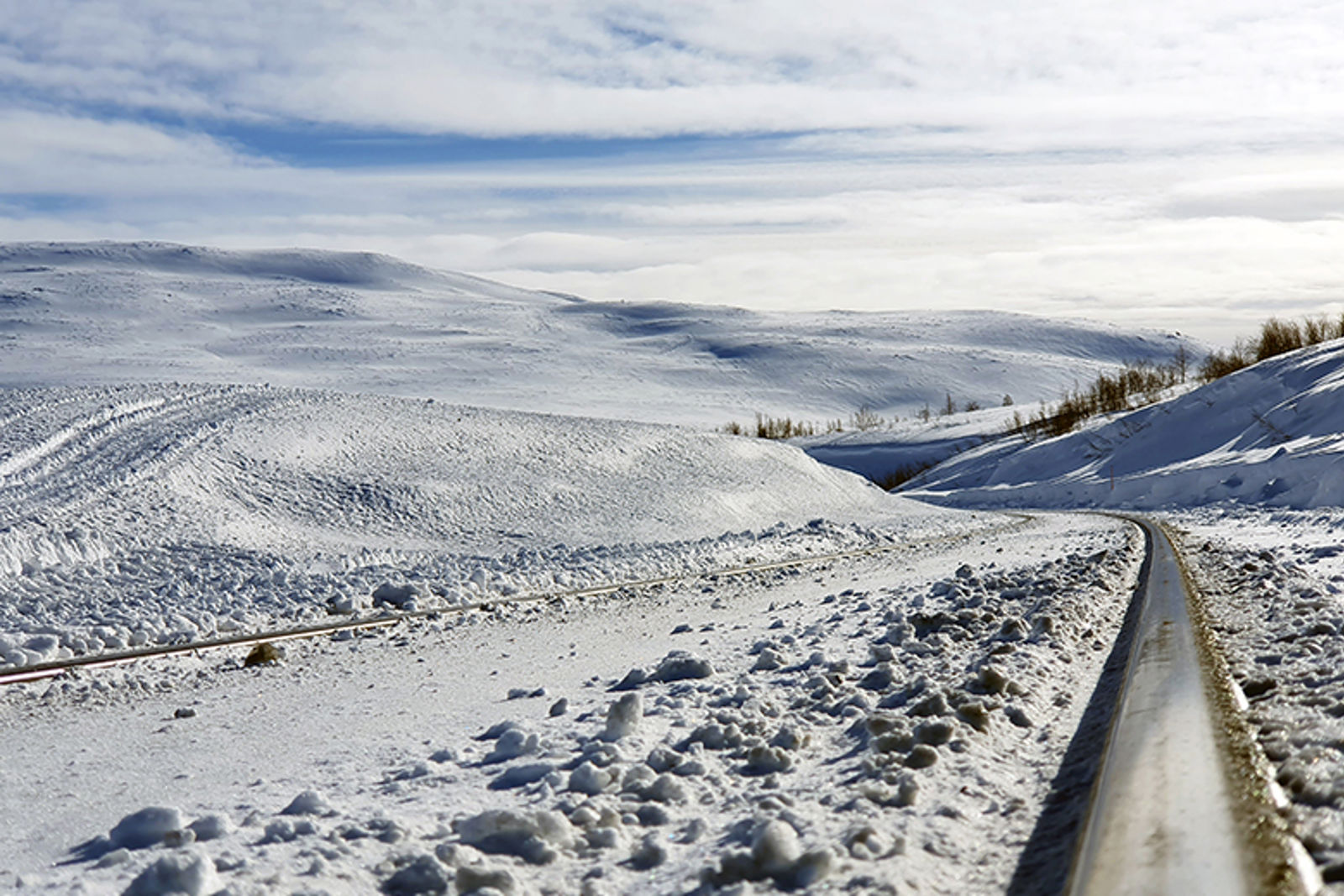 Skinner på jernbanen som går gjennom et snødekt fjellterreng.
