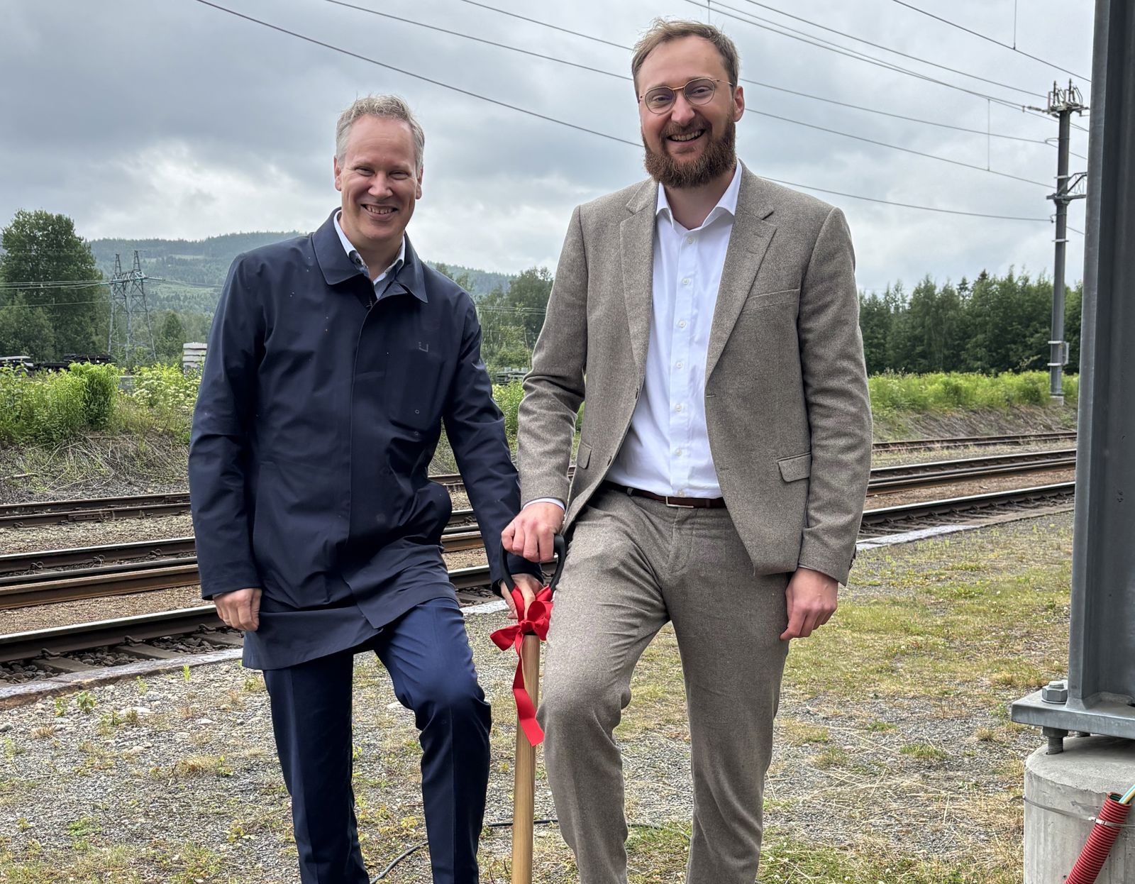 To menn smiler og ser i kamera