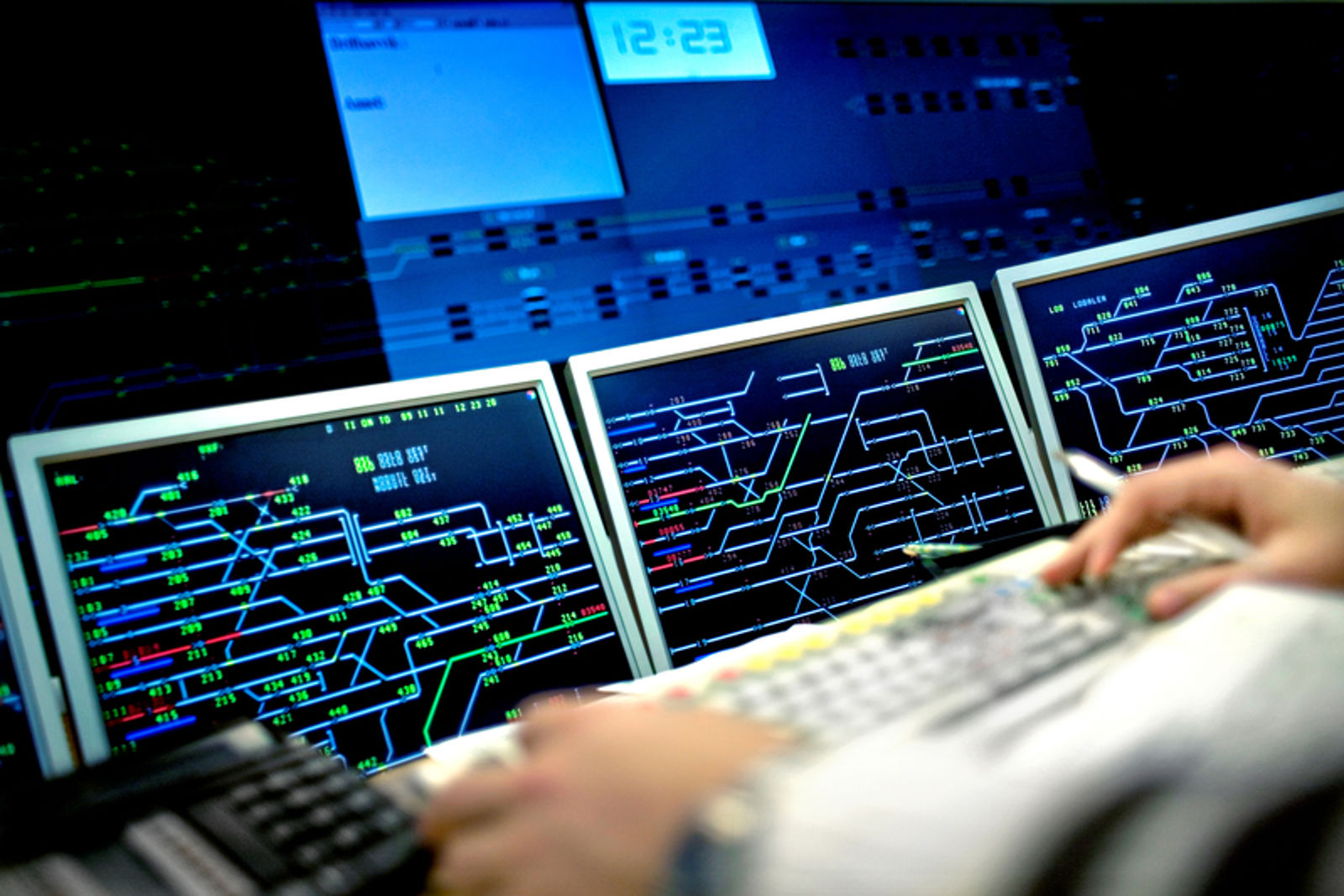 Inne på trafikkstyringssentralen, flere skjermer med oversikt over togtrafikken.