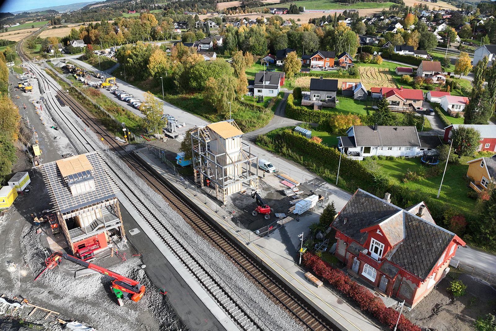 Dronefoto av stasjonsområdet med et nytt spor og bygging av overgangsbru.