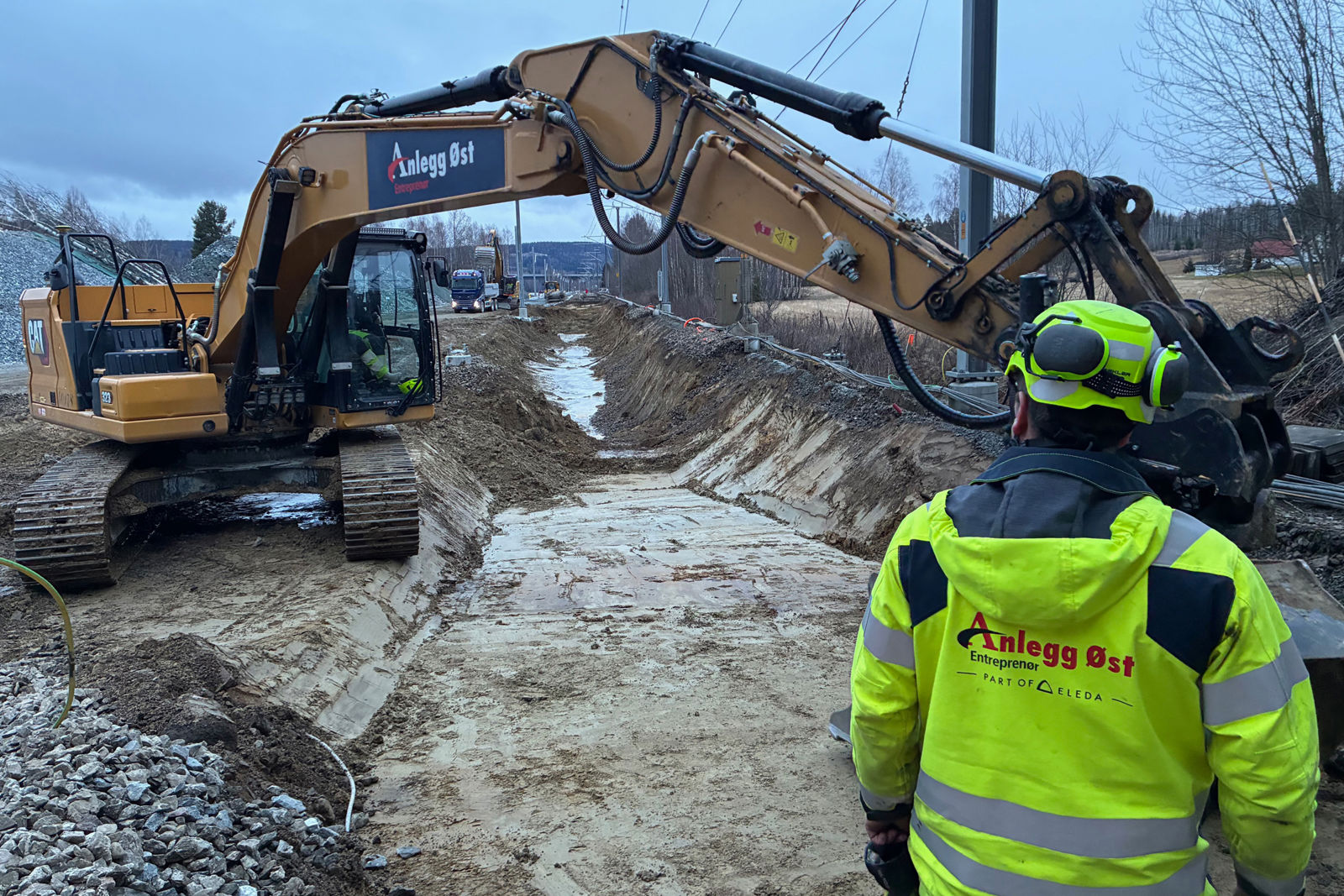 Maskin i sporet. Mann med ryggen til kamera