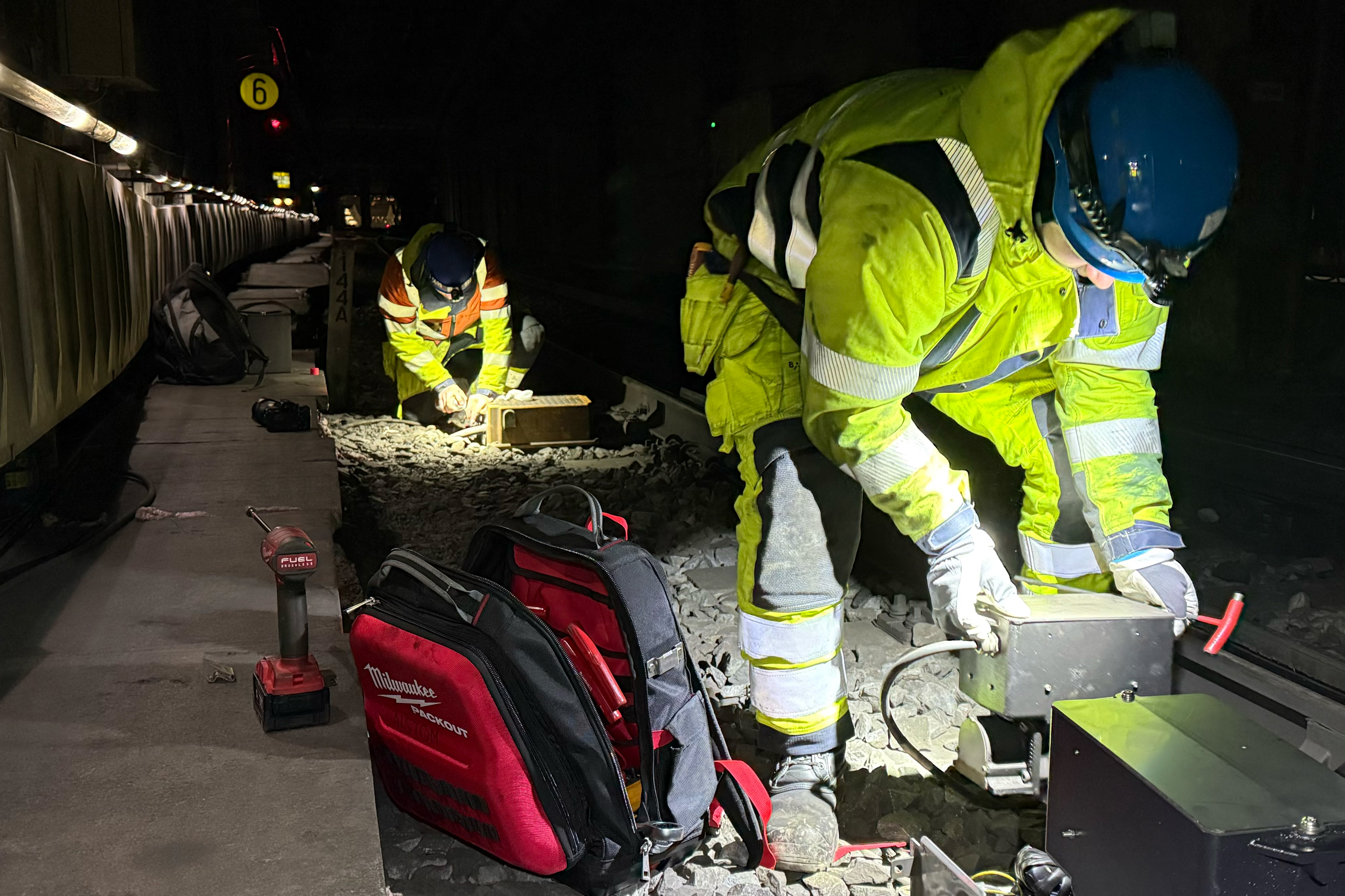 Nattbilde av arbeidere i sporet.