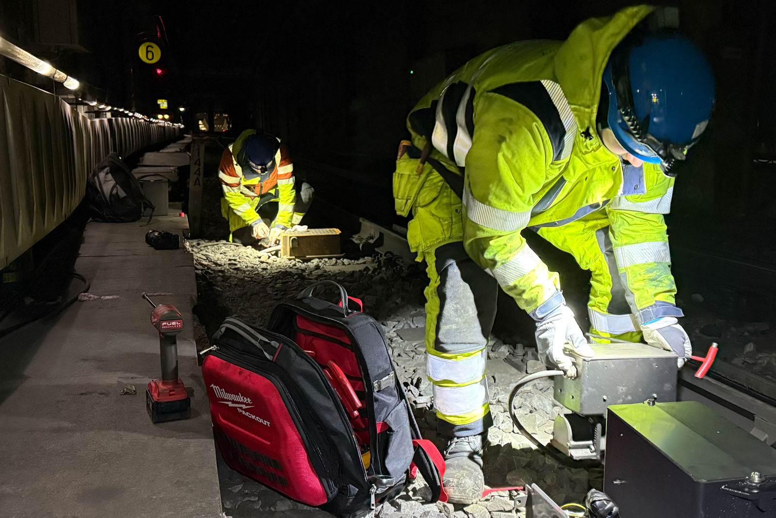 Nattbilde av arbeidere i sporet.