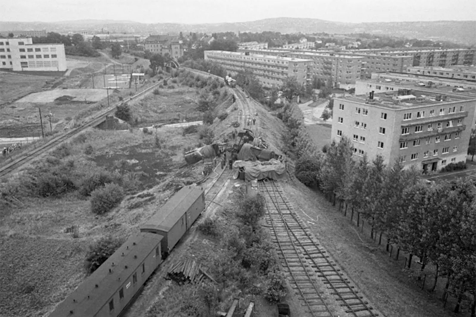 Vogner ligger hulter til bulter ved vekselen til sidesporet. Gjøvikbanen og boligblokker rundt.