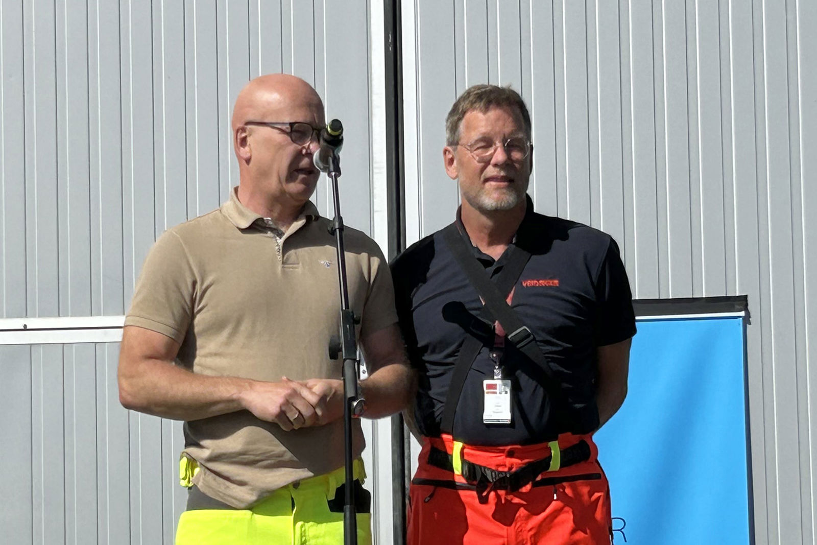 Personene står sammen ved en mikrofon for å holde tale.