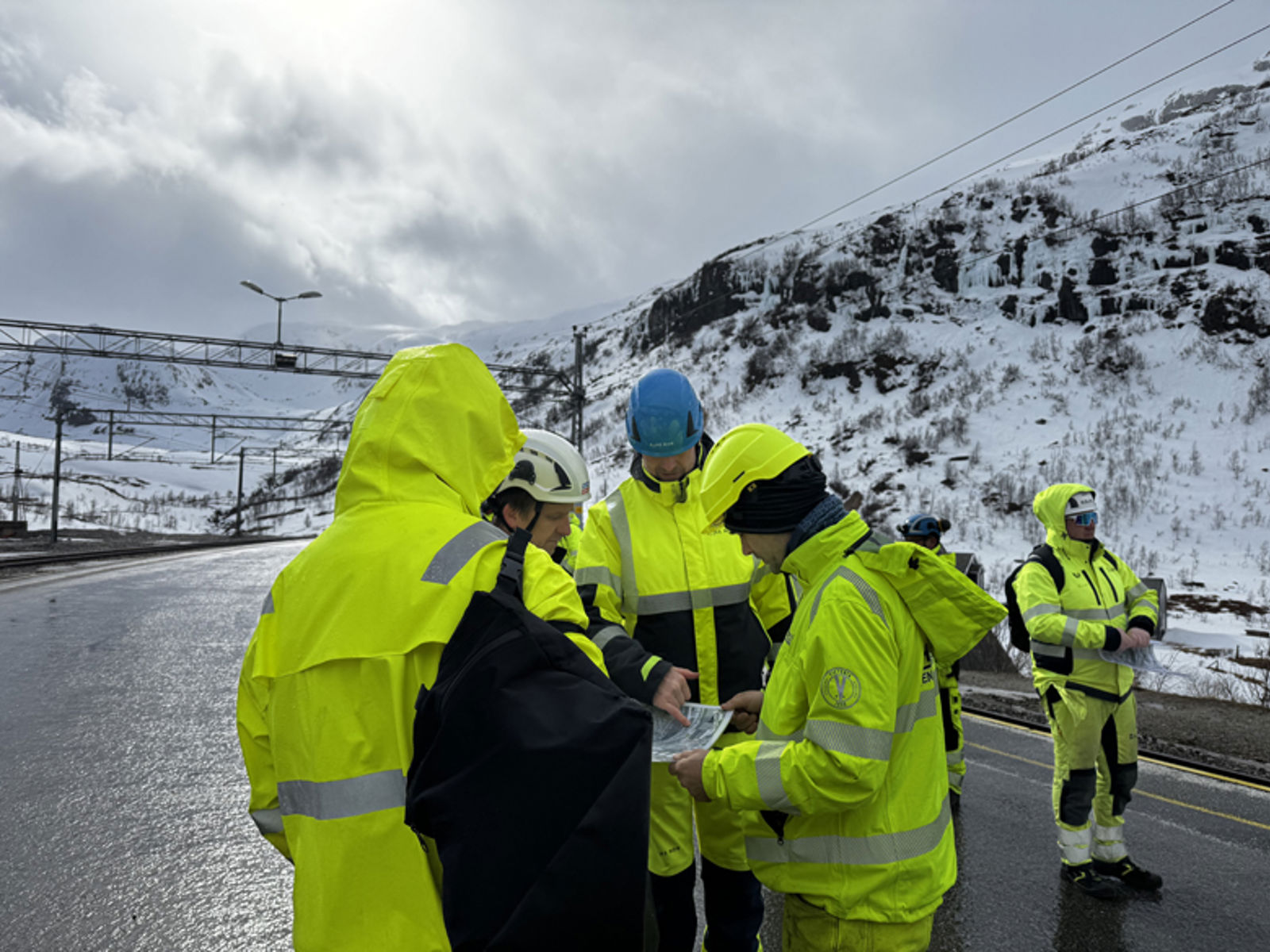 Personer i vernetøy som ser på et kart